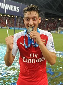 Images Dated 18th July 2015: Arsenal Celebrate Asia Trophy Victory: Mesut Ozil Lifts the Trophy (2015)