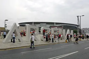 Arsenal fans gather around the giant letters near the south bridge outside the Emirates Stadium
