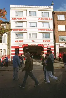 Arsenal fans walk outside the entrance to the West Stand Upper before the match