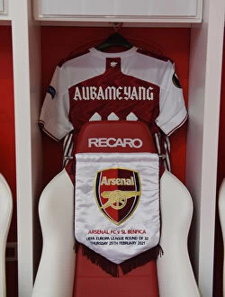 Images Dated 25th February 2021: Arsenal FC: Aubameyang's Shirt and Pennant in the Changing Room Before Arsenal v SL Benfica