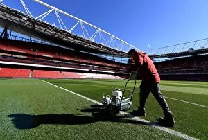 Images Dated 26th September 2018: Arsenal Groundsman Meticulously Prepares Emirates Stadium Pitch for Carabao Cup Match