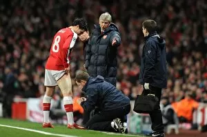 Images Dated 9th March 2010: Arsenal manager Arsene Wenger looks on as Samir Nasri is treated by physio Colin Lewin