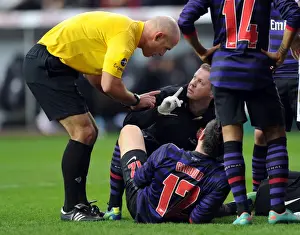 Arsenal Physio Colin Lewin treats Olivier Giroud (Arsenal) as Referee Howard Webb chats to him