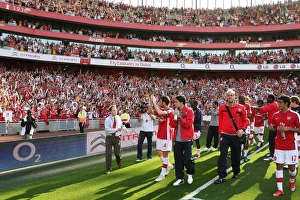 The Arsenal squad wave to the fans after the match
