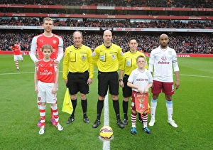 Arsenal V Aston Villa 2014-15 Prints: Arsenal vs. Aston Villa: Premier League Clash - Per Mertesacker and Fabian Delph Lead Teams Out at Emirates Stadium