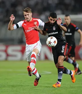 Besiktas V Arsenal 2014-15 Prints: Arsenal's Aaron Ramsey Faces Off Against Besiktas Ismail Koybasi in UEFA Champions League Qualifier