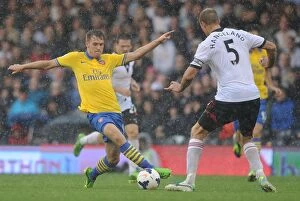 Images Dated 24th August 2013: Arsenal's Aaron Ramsey Faces Off Against Fulham's Brede Hangeland in Premier League Clash