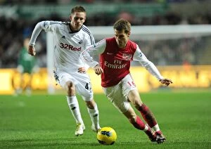 Swansea City v Arsenal 2011-12 Collection: Arsenal's Aaron Ramsey Outmaneuvers Swansea's Gylfi Sigurdsson in Premier League Clash