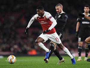 Images Dated 13th December 2018: Arsenal's Ainsley Maitland-Niles Faces Off Against Qarabag's Maksin Medvedev in Europa League Clash