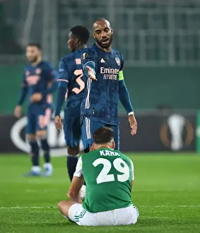 Rapid Vienna V Arsenal 2020-21 Prints: Arsenal's Alex Lacazette Stands Over Injured Rapid Wien Player in Europa League Clash