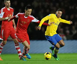 Southampton V Arsenal 2013-14 Prints: Arsenal's Alex Oxlade-Chamberlain Faces Off Against Southampton's Maya Yoshida in Premier League Clash