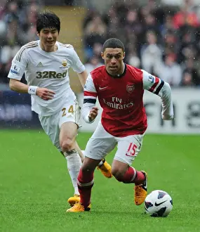 Swansea Prints: Arsenal's Alex Oxlade-Chamberlain Outmaneuvers Ki Sung-Yueng of Swansea