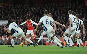 Arsenal's Alexis Sanchez Goes Head-to-Head with Claudio Yacob and Jonny Evans in Intense Football Battle