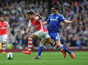 Arsenal V Chelsea 2014/15 Prints: Arsenal's Alexis Sanchez Outmaneuvers Cesc Fabregas: A Tactical Battle at the Emirates