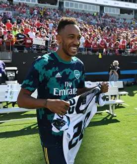Arsenal V Fiorentina 2019-20 Prints: Arsenal's Aubameyang Receives Carolina Panthers Shirt from Christian McCaffrey Ahead of Arsenal v Fiorentina Match
