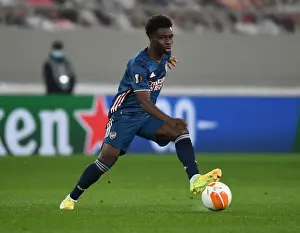Olympiacos V Arsenal 2020-21 Prints: Arsenal's Bukayo Saka in Action at Empty Karaiskakis Stadium: Olympiacos vs