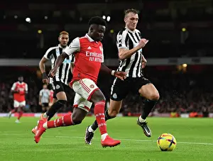 Arsenal's Bukayo Saka Clashes with Newcastle's Dan Burn in Premier League Showdown