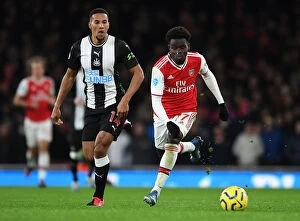 Arsenal v Newcastle United 2019-20 Collection: Arsenal's Bukayo Saka Clashes with Newcastle's Isaac Hayden in Premier League Showdown