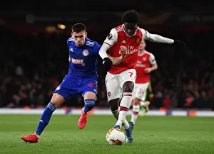 Arsenal V Olympiacos 2019-20 Prints: Arsenal's Bukayo Saka Clashes with Olympiacos Lazar Randjelovic in Europa League Showdown