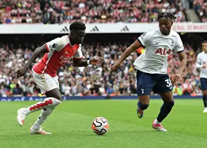 Arsenal V Tottenham Hotspur 2023-24 Prints: Arsenal's Bukayo Saka Clashes with Tottenham's Destiny Udogie in the 2023-24 Premier League Showdown