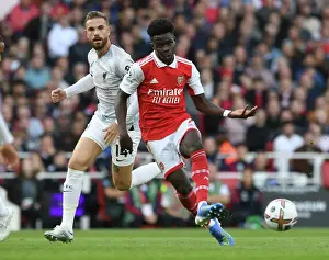 Arsenal's Bukayo Saka Evades Liverpool's Jordan Henderson in Premier League Showdown