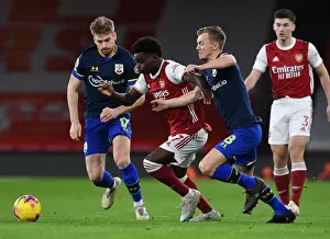 Arsenal's Bukayo Saka Faces Off Against Southampton's Stuart Armstrong and James Ward-Prowse in Premier League Clash