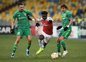 FC Vorskla Poltava V Arsenal 2018-19 Prints: Arsenal's Bukayo Saka Faces Off Against Vorskla Poltava's Sharpar and Rebenok in UEFA Europa League Clash