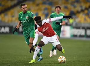FC Vorskla Poltava V Arsenal 2018-19 Prints: Arsenal's Bukayo Saka Faces Off Against Vyacheslav Sharpar in Europa League Clash