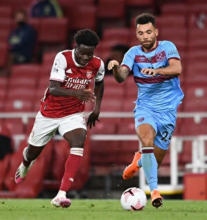 Images Dated 19th September 2020: Arsenal's Bukayo Saka Faces Off Against West Ham's Ryan Fredericks in Premier League Clash