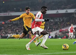Arsenal's Bukayo Saka Faces Pressure from Wolves Hugo Bueno during the Arsenal v Wolverhampton Wanderers Premier League Match (2023-24)