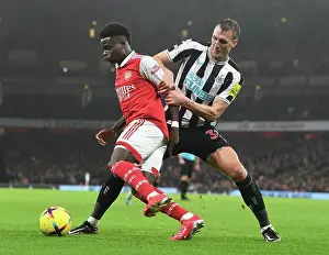 Arsenal's Bukayo Saka Fends Off Newcastle's Dan Burn in Premier League Clash