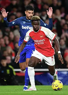 Arsenal's Bukayo Saka Fends Off West Ham's Emerson Palmieri in Premier League Clash (2023-24)