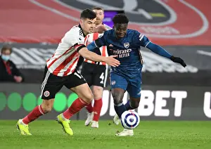 Arsenal's Bukayo Saka Outmaneuvers Sheffield United's John Egan in Empty Bramall Lane