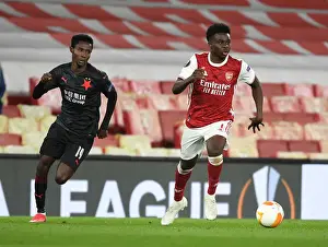 Arsenal's Bukayo Saka Outmaneuvers Slavia Praha's Oscar Dorley in UEFA Europa League Quarterfinal at Empty Emirates Stadium