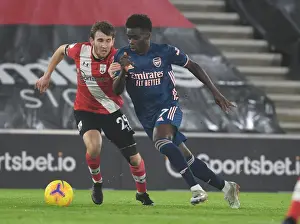Southampton V Arsenal 2020-21 Prints: Arsenal's Bukayo Saka Outmaneuvers Southampton's Jake Vokins in Empty St