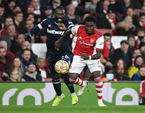 Arsenal V West Ham United 2021-22 Prints: Arsenal's Bukayo Saka Outmaneuvers West Ham's Arthur Masuaku in Premier League Clash