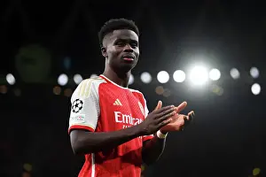 Arsenal V Sevilla 2023-24 Prints: Arsenal's Bukayo Saka Salutes Appreciative Fans after a Hard-Fought UEFA Champions League Match vs Sevilla (2023-24)