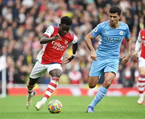 Arsenal's Bukayo Saka Takes on Rodri in Intense Arsenal v Manchester City Clash (Premier League 2021-22)