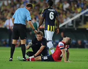 Fenerbahce V Arsenal 2013-14 Prints: Arsenal's Colin Lewin Tends to Jack Wilshere's Injury in Fenerbahce Showdown