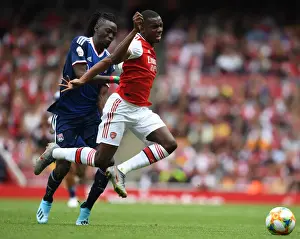 Arsenal's Eddie Nketiah Outmaneuvers Olympique Lyonnais Bertrand Traore during the 2019-20 Emirates Cup Match