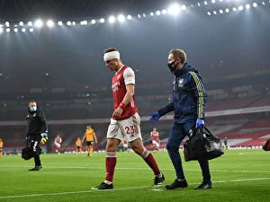 Arsenal v Wolverhampton Wanderers 2020-21 Collection: Arsenal's Empty Emirates: David Luiz Receives Treatment Alone Amidst Quiet Stadium Crowds