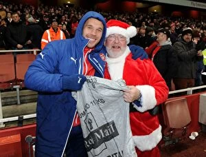 Images Dated 13th December 2014: Arsenal's Festive Surprise: Lukas Podolski and the Arsenal Chef Dressed as Father Christmas Ahead