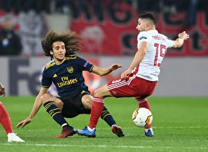 Olympiacos v Arsenal 2019-20 Collection: Arsenal's Guendouzi Faces Off Against Olympiacos Masouras in Europa League Clash