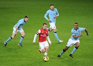 Manchester City Collection: Arsenal's Jack Wilshere Faces Off Against Manchester City's Milner, Garcia, and Kompany