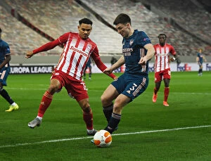 Images Dated 12th March 2021: Arsenal's Kieran Tierney Clashes with Olympiacos Kenny Lala in Empty Europa League Stadium