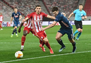 Images Dated 12th March 2021: Arsenal's Kieran Tierney Goes Head-to-Head with Olympiacos' Lazar Randjelovic in Empty Europa