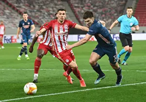 Olympiacos V Arsenal 2020-21 Prints: Arsenal's Kieran Tierney Goes Head-to-Head with Olympiacos Lazar Randjelovic in Empty Europa League Stadium