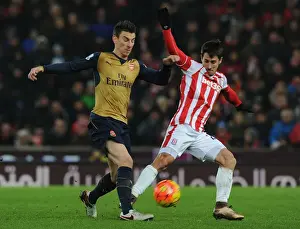 Stoke City V Arsenal 2015-16 Prints: Arsenal's Koscielny Goes Head-to-Head with Stoke's Bojan in Intense Premier League Showdown