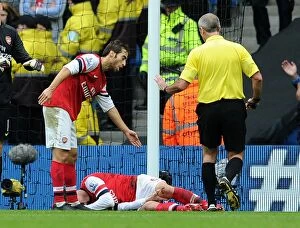 Manchester City v Arsenal 2013-14 Collection: Arsenal's Koscielny Injured as Flamini Waves for Help vs Manchester City (2013-14)