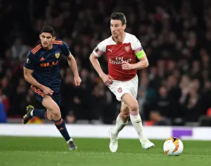 Arsenal's Laurent Koscielny Battles Past Valencia's Goncalo Guedes in UEFA Europa League Semi-Final Showdown